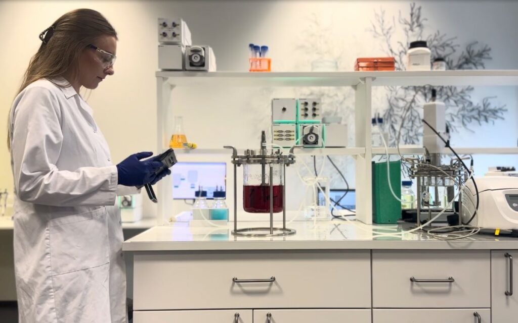 Researcher checking process data on modular bioprocess control hardware