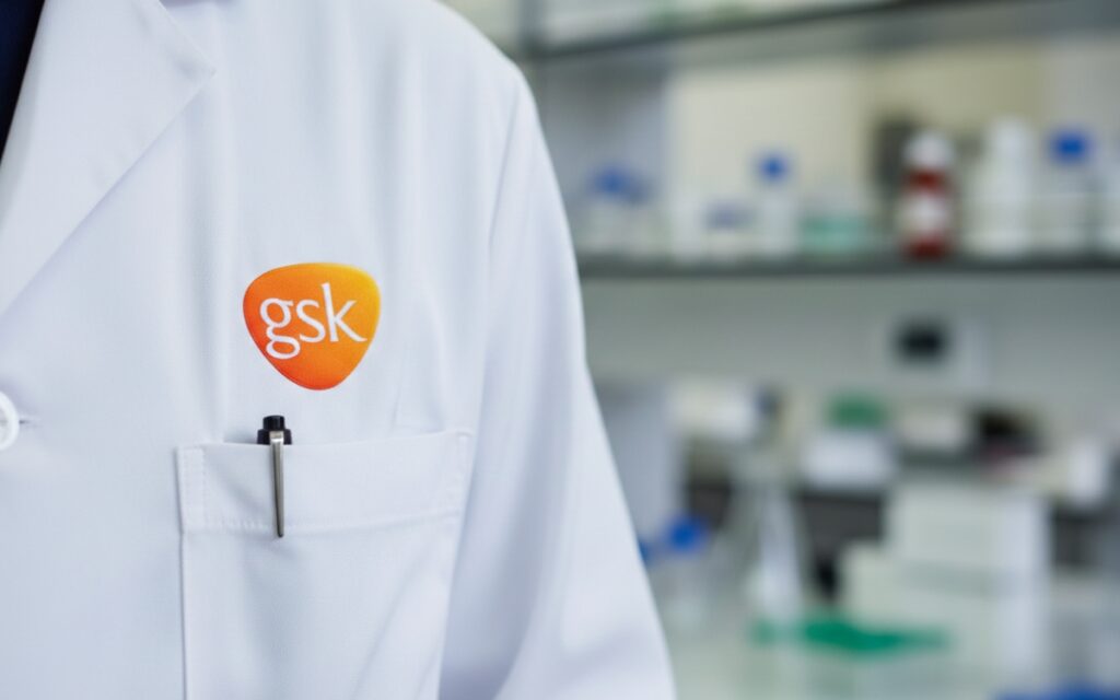GSK logo on laboratory coat representing immunology and biotech acquisition activity