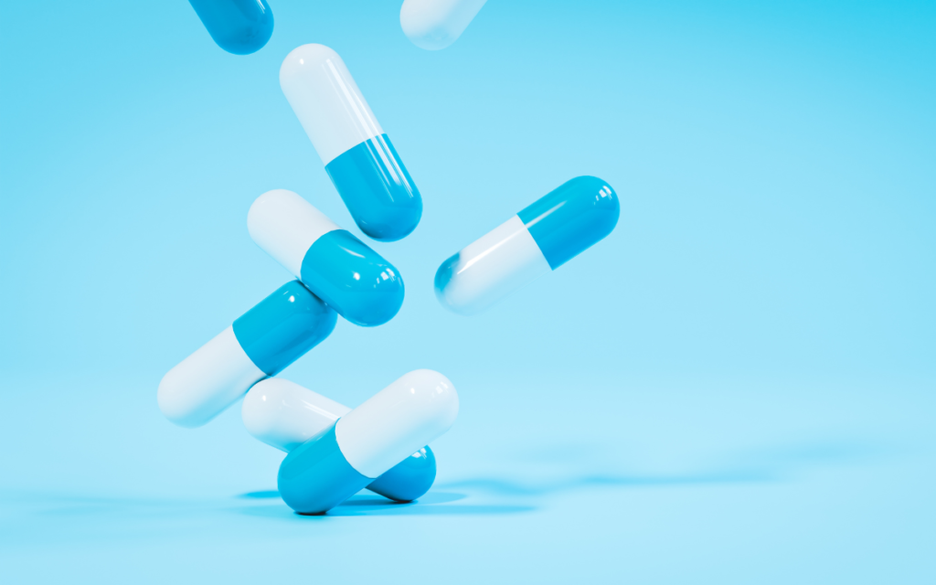 Blue and white fertility supplements falling to illustrate clinical research