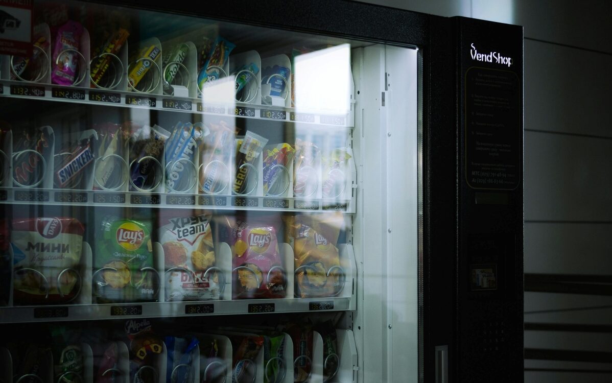 Vending-Machine Vending machine stocked with sugary drinks and processed snacks.