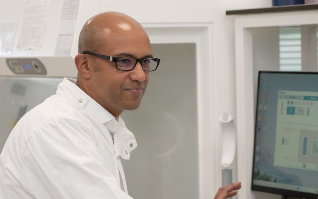 Speech biomarker neurodegenerative disease researcher working at computer in laboratory