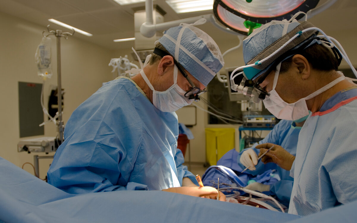 Surgeons operating in theatre, the acute window where kidney care investment could preserve renal function.