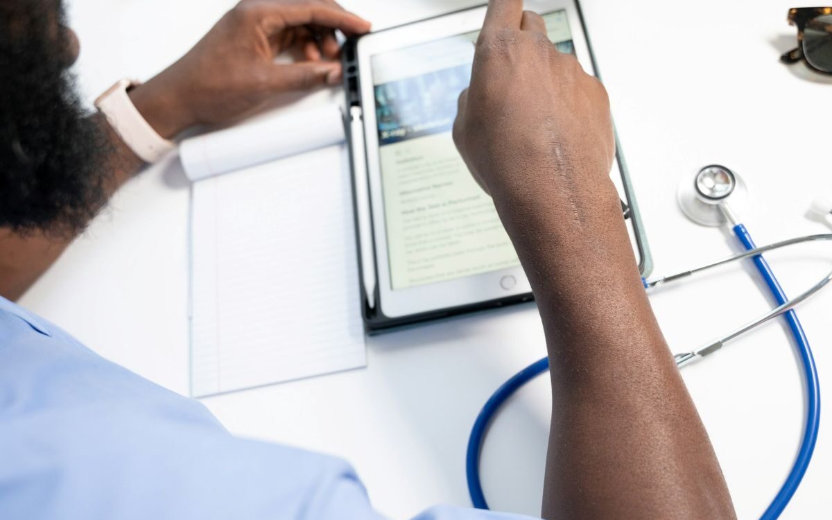 nappy-EjajCMK7CJM-unsplash Healthcare professional reviewing care matching data on a tablet beside a stethoscope and notepad