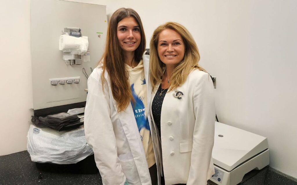 Two women standing in a research lab with a centrifuge, highlighting women-led biotech leadership